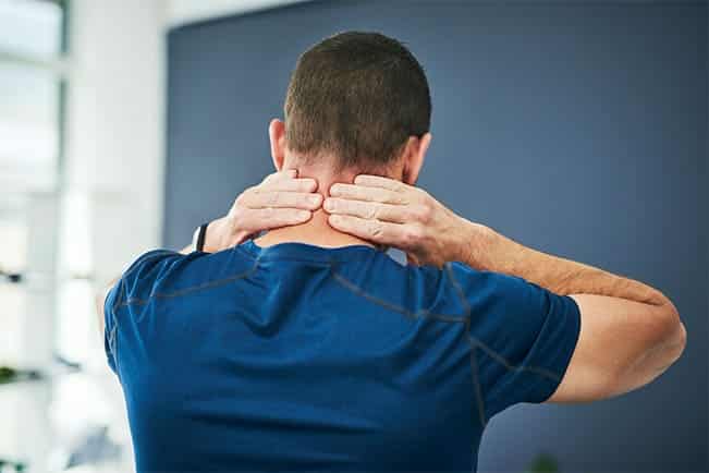 Patient holding the back of their sore neck